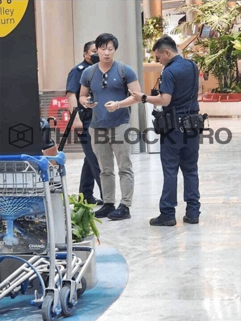 Su Zhu being stopped by police in Changi airport.